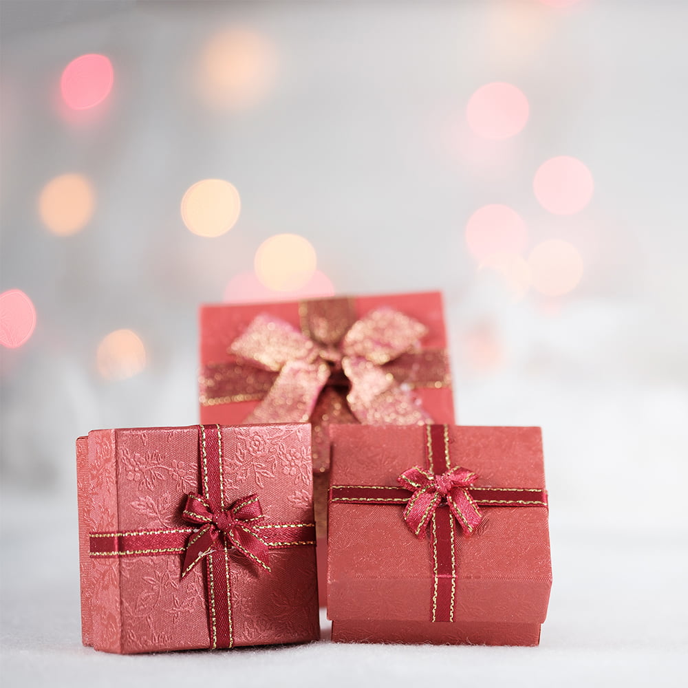 Closeup of three Christmas presents in red boxes.