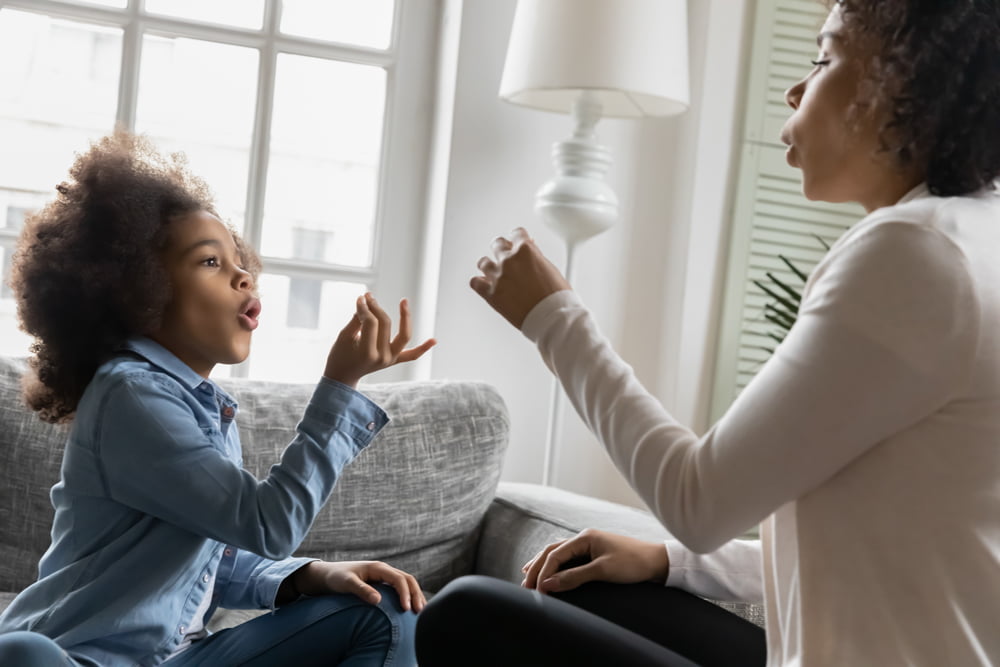 Excited child communicating non-verbally with female adult