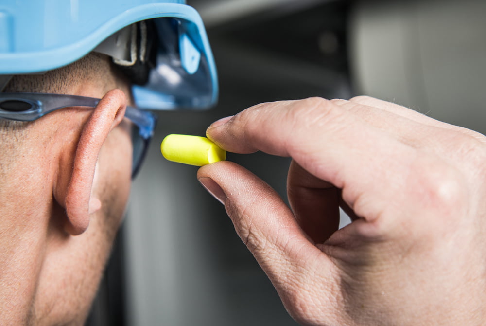 Man inserting hearing protection inside his ear